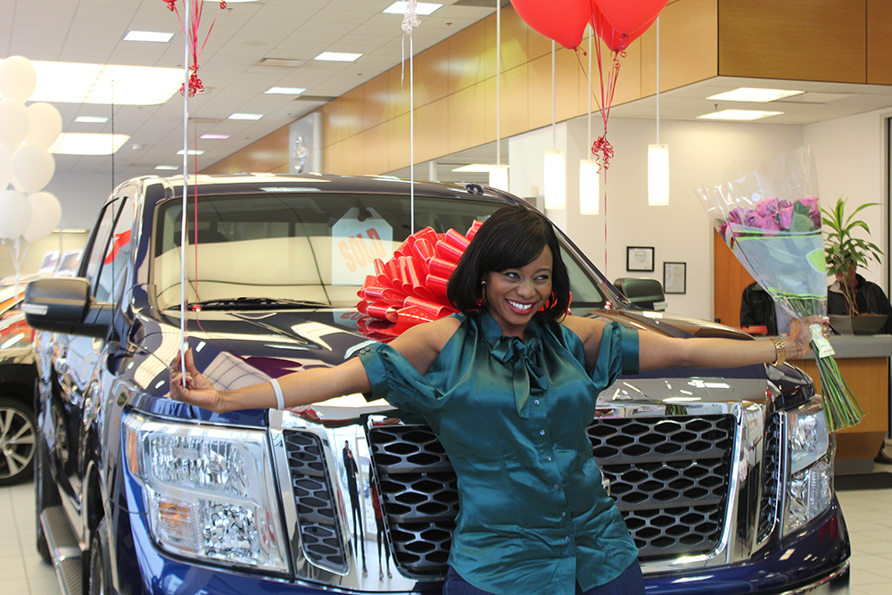 Eniola posing in front of her new 2017 Nissan titan she won as part of the Nissan Great Getaways Service Sweepstakes